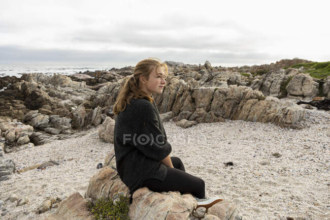 Девочка-подросток изучает каменистый актёрский состав De Kelders, Южная Африка — стоковое фото