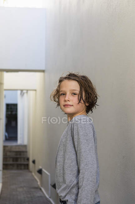 Porträt eines kleinen Jungen in einer engen Gasse, der sich der Kamera zuwendet — Stockfoto