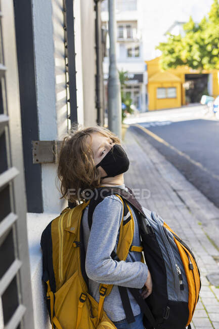 Мальчик с рюкзаком в черной маске на улице. — стоковое фото