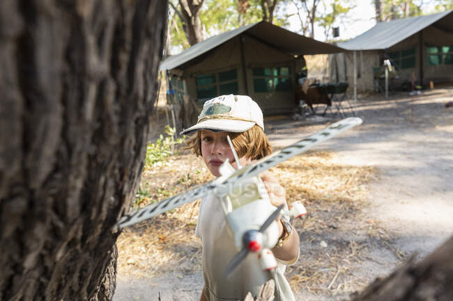 Kleiner Junge im Safarizelt mit Modellflugzeug. — Stockfoto