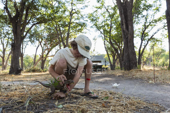Jeune garçon dans le camp de safari sous tente payer avec un jouet vert dinosaure — Photo de stock