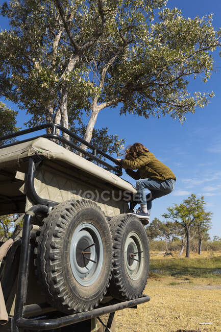 Young boy climbing up into a safari vehicle — Stock Photo