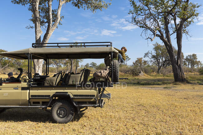 Young boy climbing up into a safari vehicle — Stock Photo