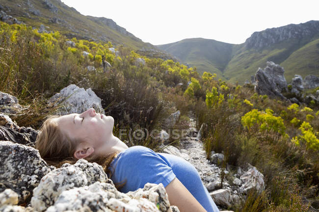 Adolescente se inclinando para trás e descansando ao sol em um caminho trilha natureza — Fotografia de Stock