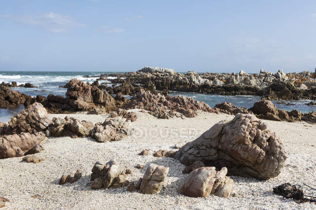 Plage de sable et de galets avec des roches dentelées, sur la côte atlantique. — Photo de stock