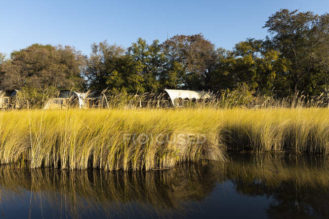 A permanent tented camp by a waterway channel — Stock Photo