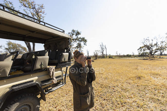 Donna con binocolo, Delta dell'Okavango, Botswana — Foto stock