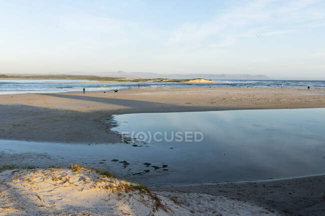 Una amplia playa de arena con marea baja y vista a lo largo de las dunas de la costa atlántica - foto de stock