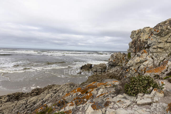 Las rocas dentadas y la costa de la costa atlántica en Grotto Beach, una amplia playa cerca de Hermanus. - foto de stock