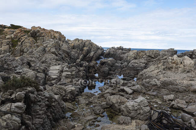 Rocky jagged coastline, rock pool and view out to the ocean — Stock Photo