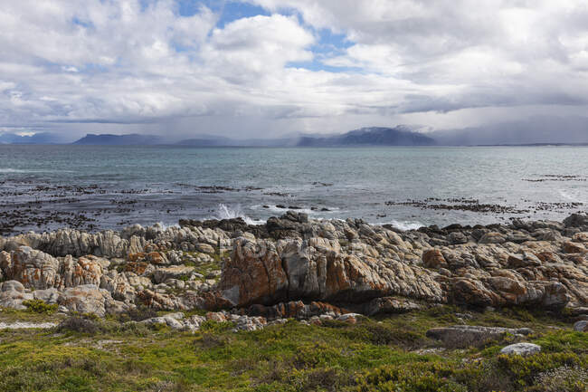 Скалистое неровное побережье, эродированная скала из песчаника, вид на океан — стоковое фото