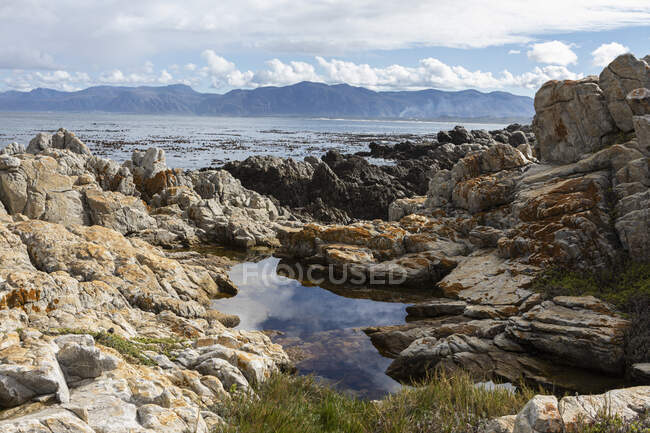 Costa dentada rocosa, piscina de roca y vista al océano - foto de stock