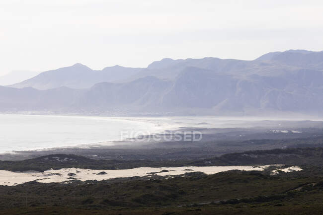 View of a mountain range and river estuary, mist and sea fret, coastline. — Stock Photo