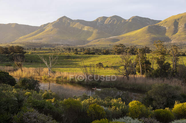 View across a tranquil landscape, river valley and a mountain range — Stock Photo