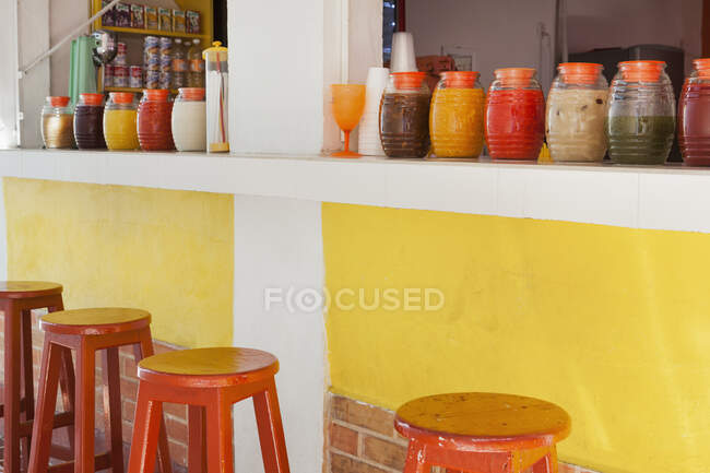 Bar stools,and rows of juice bottles, market stall and drinks stand — Foto stock