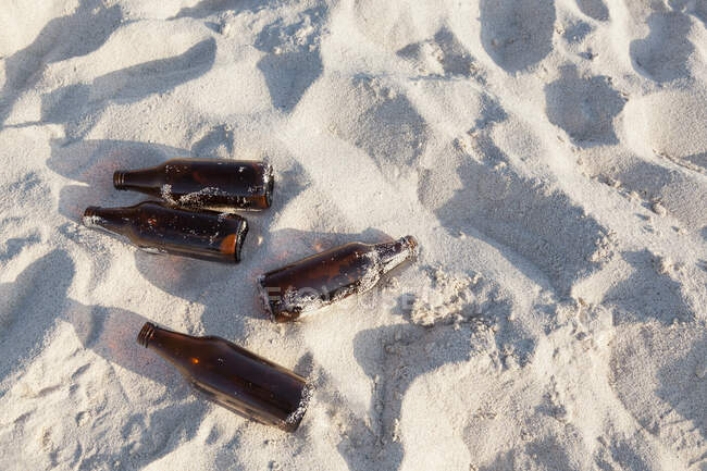 Vazio abandonado garrafas de cerveja na praia — Fotografia de Stock
