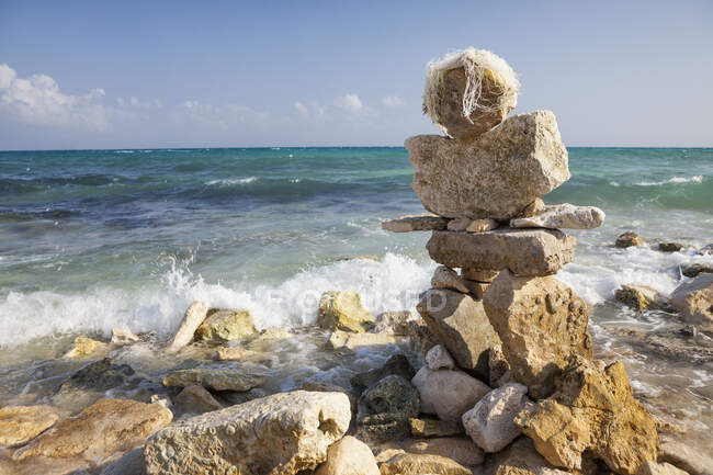 A cairn, pile of stones on the beach at the water's edge — Foto stock