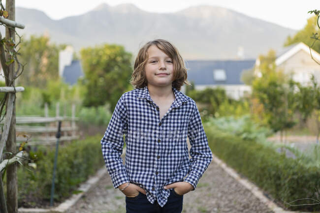 Портрет восьмилетнего мальчика, улыбающегося, руки в карманах — стоковое фото