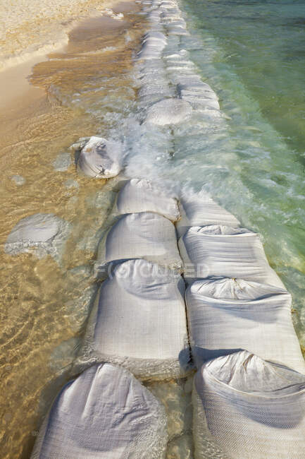 Sandbags in rows at the water's edge to prevent erosion of the beach — Foto stock