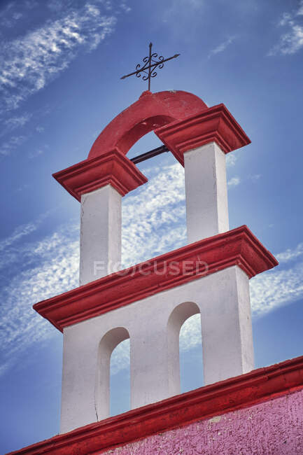 Архитектурные детали, красно-белая краска и железный крест на крыше церкви в Канкуне. — стоковое фото