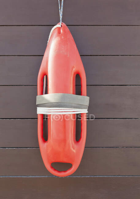 Orange lifeguard buoy, a safety float hanging on a wood wall — Foto stock