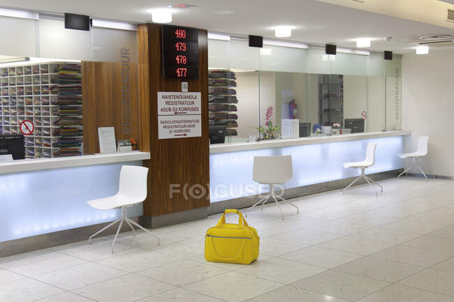 Wartebereich und Rezeption in einem modernen Krankenhaus, mit Schildern und elektronischer Anzeige Gelber Sack. — Stockfoto