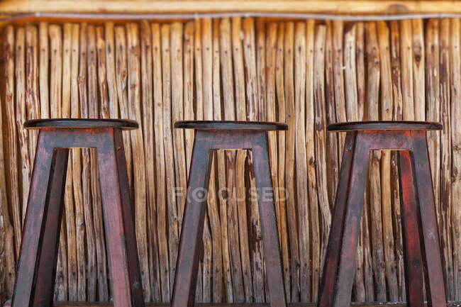 Tres taburetes y bar en una playa - foto de stock