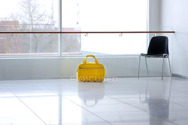 A yellow bag in a light and airy empty corridor  Yellow bag. — Stock Photo