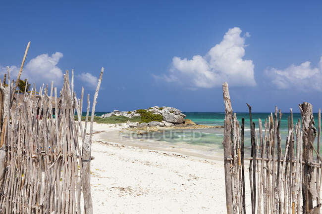 Проход в заборе на пляж с белым песком — стоковое фото