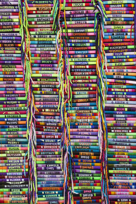 Pulseras de colores brillantes con nombres bordados en un puesto de mercado. - foto de stock