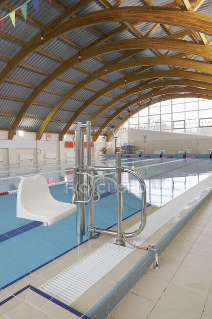 Indoor swimming pool, a chair and hoist for disabled people. — Stock Photo