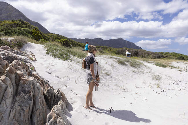 Erwachsene Frau trägt Picknickkorb am Grotto Beach, Hermanus, Western Cape, Südafrika. — Stockfoto