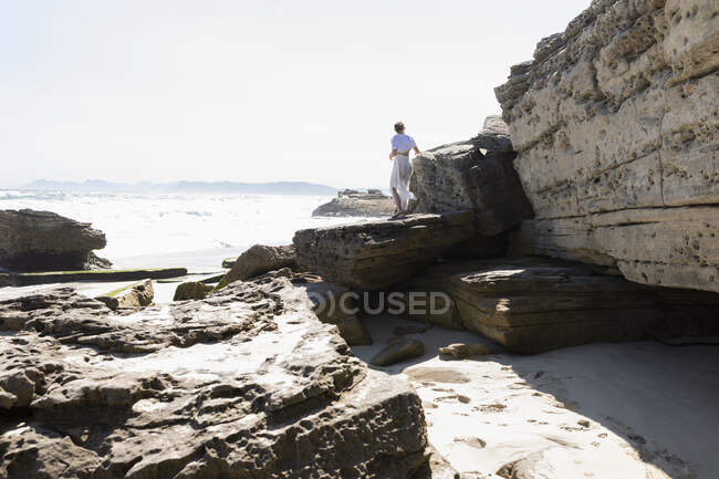 Дівчинка підліткового віку досліджує скелі й скелясті пласти на березі Атлантичного океану.. — стокове фото
