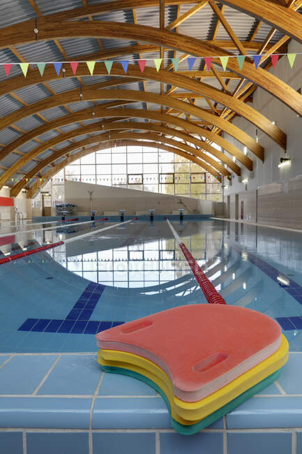 Indoor swimming pool, starting block, diving block and marked lanes, flat calm water — Stockfoto