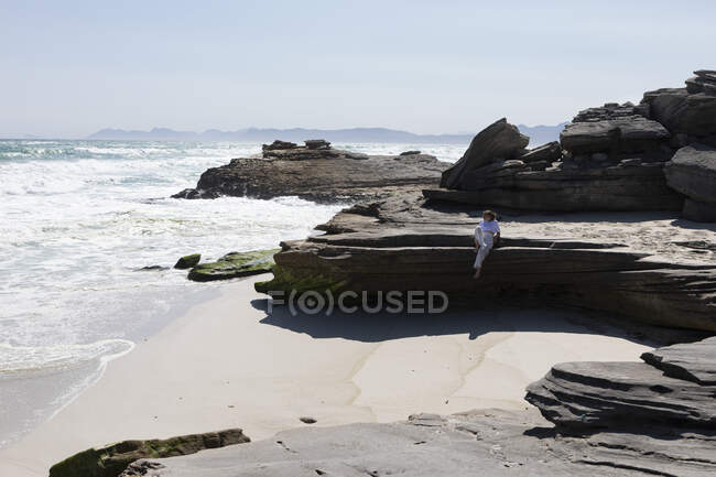 Adolescente explorant une côte rocheuse sur la côte de l'océan Atlantique — Photo de stock