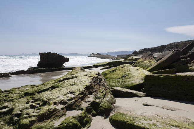 A costa da Reserva Natural Walker Bay do Oceano Atlântico, com pilares rochosos intemperizados e rochas planas lisas. — Fotografia de Stock