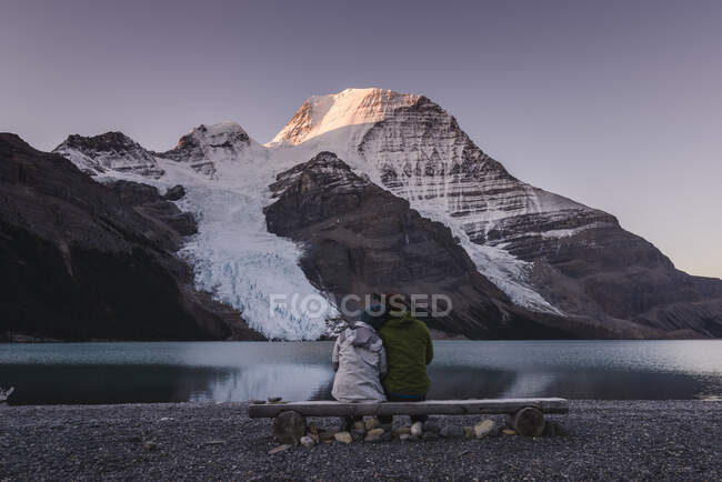 Casal na frente do Monte Robson acima do lago Berg ao amanhecer. — Fotografia de Stock