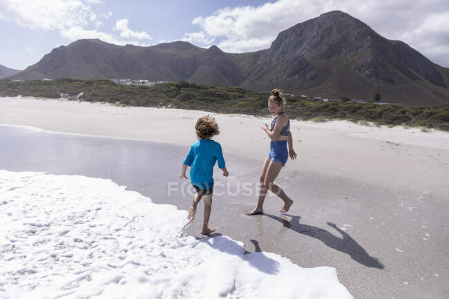 Children playing in surf, Grotto Beach, Hermanus, Western Cape, South Africa. — Stockfoto