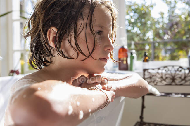 Menino de oito anos em uma banheira, tomando banho — Fotografia de Stock