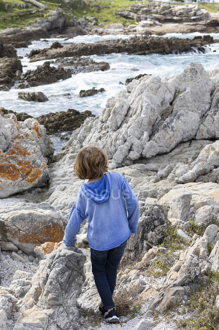 Young boy in a blue shirt walking on a path to the beach — Stock Photo