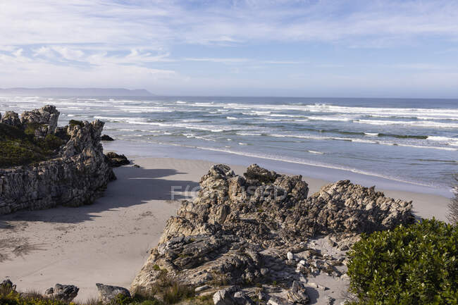 Песчаный пляж и скалы, возвышенный вид, волны, разбивающиеся о берег. — стоковое фото