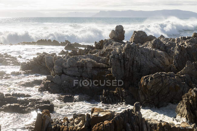 Крилаті скелі на березі біля Де Келдерса, високі хвилі прокочуються всередину і ламають скелі. — стокове фото