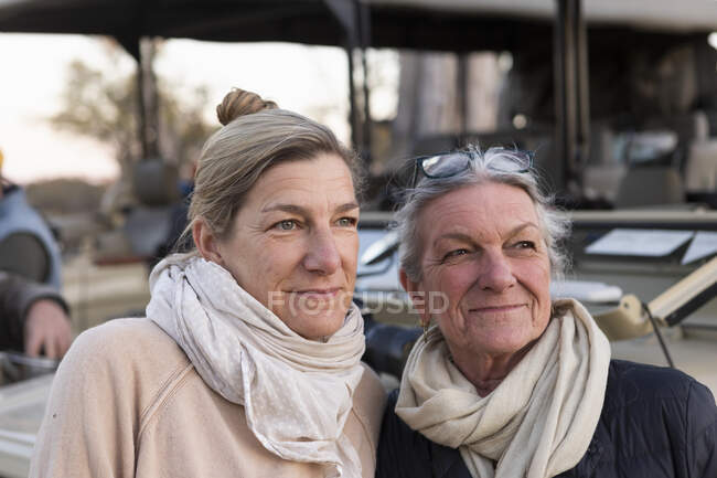 Dos mujeres al lado de un vehículo de safari, mujer adulta y su madre, semejanza familiar - foto de stock