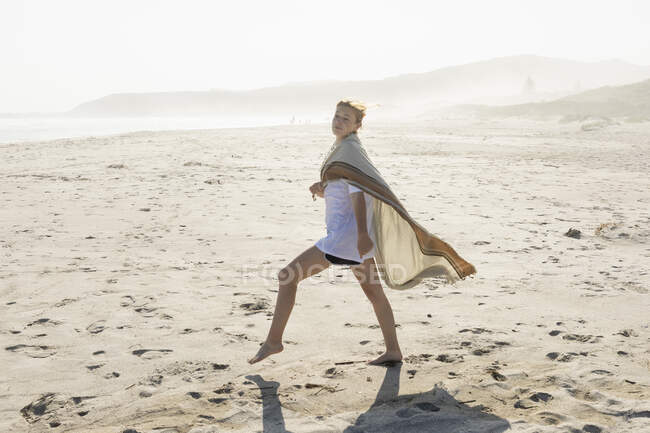 Adolescente bailando en una playa de arena - foto de stock