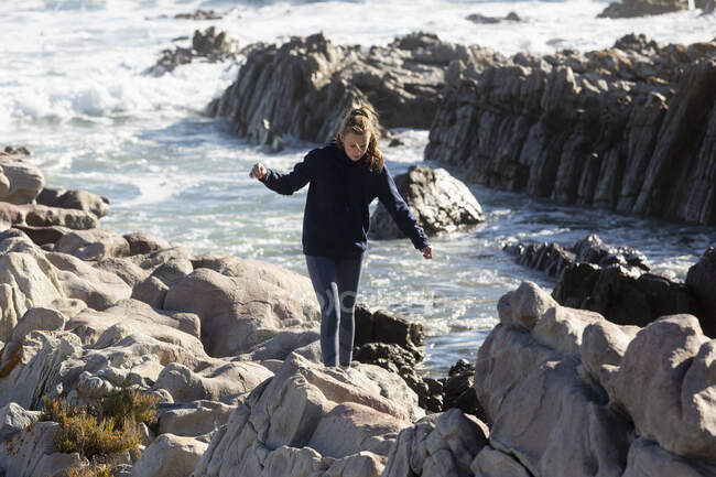 Teenage girl climbing rocks, De Kelders, Sudafrica — Foto stock