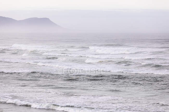 Вигляд через піщаний пляж, густий туман і хвилі, що розбиваються об атлантичне узбережжя.. — стокове фото