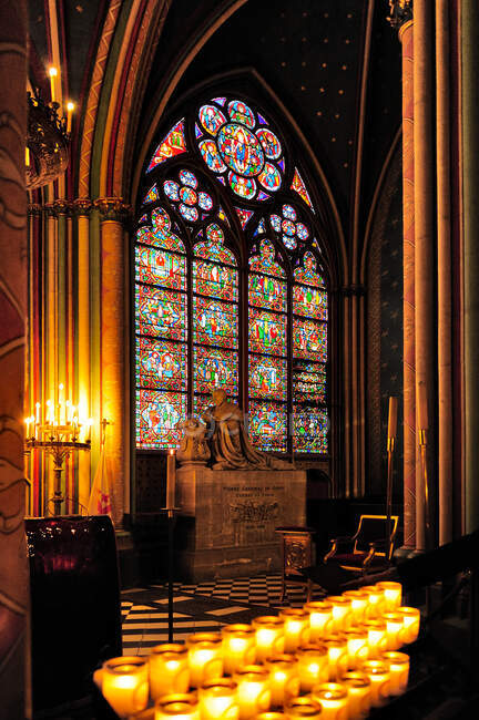 Interior of Notre Dame cathedral in Paris, before the fire of 2019, a stained glass window and rows of lit candles — Stock Photo