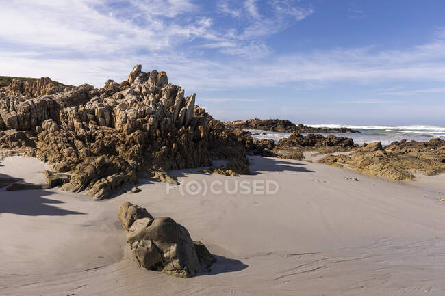 Vista sobre uma praia arenosa e formações rochosas na costa atlântica. — Fotografia de Stock