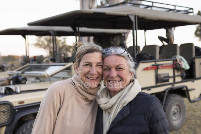 Due donne affiancate da un veicolo safari, donna adulta e sua madre, somiglianza familiare — Foto stock