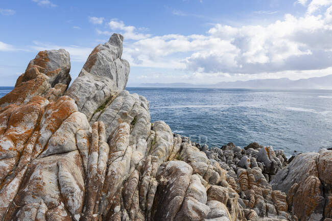 Rocas dentadas en la costa atlántica, olas en la superficie del agua. - foto de stock